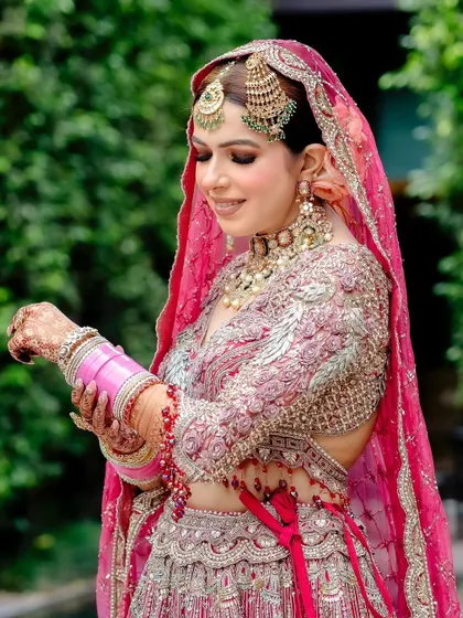 The bride adjusting her bangles, with her intricate mehendi on display.