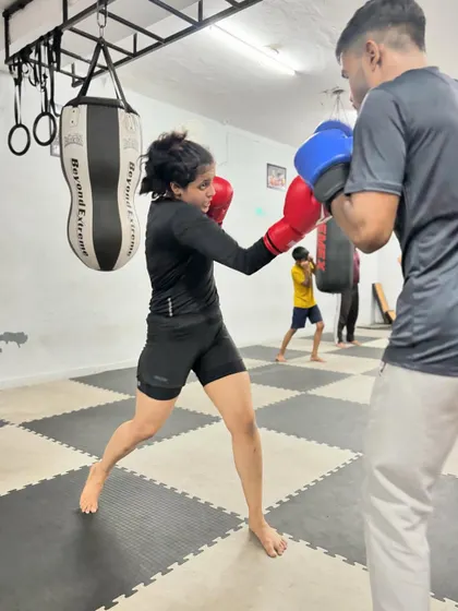 A female fighter works on her cross punch during a drill. We train our students to be sharp, technical, and powerful.