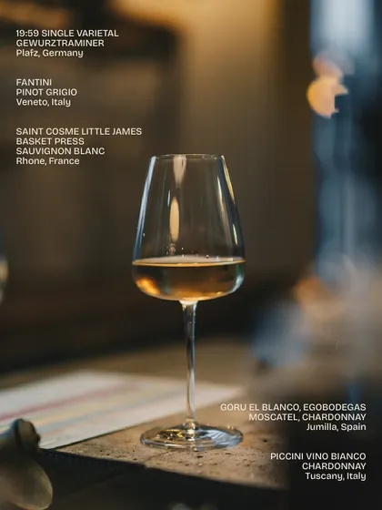 A single glass of white wine from our extensive list. This image highlights some of our selections, including a German Gewürztraminer, an Italian Pinot Grigio, and a French Sauvignon Blanc.