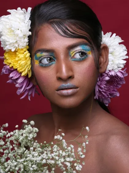 A serene, side-profile view that offers a different perspective on this floral and colorful editorial makeup.