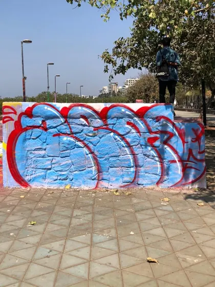 A red and blue throw-up on a public wall at Bandra Skate Park, Mumbai. This is graffiti in its natural habitat, part of the urban fabric.