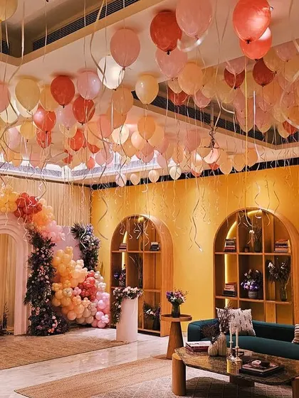 This wide view shows how our decor transformed the entire room into a cohesive and beautiful space for the baby shower. The floating ceiling balloons tie in perfectly with the main backdrop, creating an immersive experience.