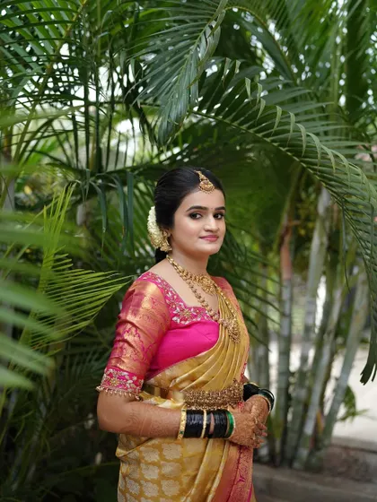 This portrait against a natural green background makes the colors of her saree and the warmth of her makeup pop.