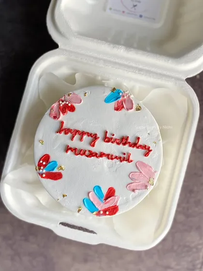 A colorful hand-painted bento cake with a personalized birthday message. The abstract floral design makes this mini cake a unique and artistic treat.