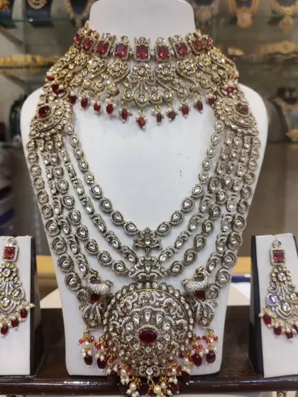 A magnificent Victorian-style bridal set with deep red stones and a large, circular pendant. This is a truly regal choice for a reception.