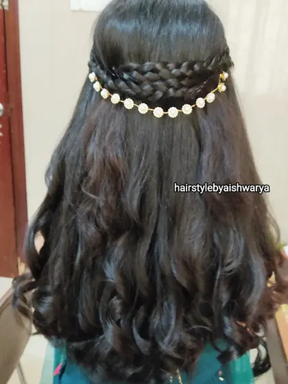 A lovely half-up hairstyle with multiple braids and soft waves. The delicate hair chain adds a touch of elegance to this romantic look.