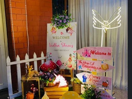 The welcome area for a fairy 'Onderland' party. We used a variety of props like directional signs, a light-up unicorn, and floral arrangements to create an enchanting entrance.