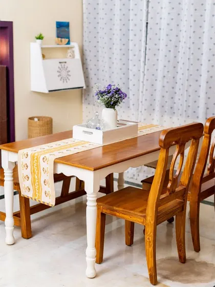 A classic farmhouse dining set featuring a table with turned legs and matching wooden chairs. The two-tone finish on the table adds to its rustic charm, creating a warm and inviting dining experience.