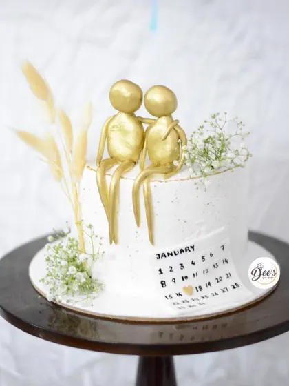 A simple yet deeply personal anniversary cake. The golden figurines and calendar marking the special day make this a wonderfully romantic and customized centerpiece.