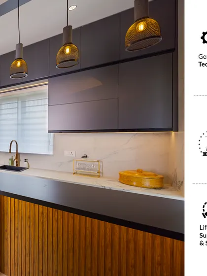 We combine German techniques, 14 years of experience, and lifetime support to create kitchens that are built to last. This design features dark matte cabinets, a wooden fluted panel, and stylish pendant lights.