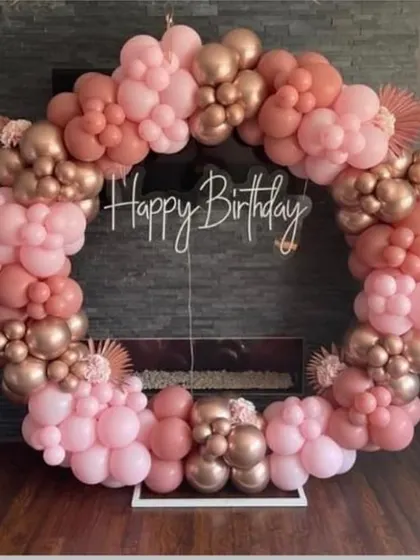 An elegant circular balloon arch in dusty rose and rose gold. This sophisticated color combination is perfect for a chic birthday celebration or bridal shower.