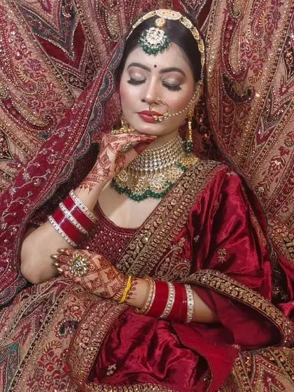A classic red and green bridal combination. This bride is wearing a custom Kundan choker with green gemstone drops, a matching maang tikka, and a traditional nath.