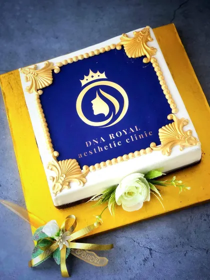 The DNA Royal logo decorates our cake for the clinic's opening, with gold-and-blue details around the square design.