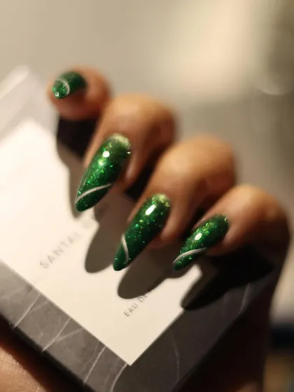 It's giving Christmas tree vibes. This deep green glitter polish with a simple white swirl is perfect for a chic holiday look.