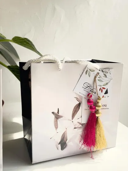 The final product: an elegant gift bag with a custom thank you tag and a beautiful tassel, ready to be handed out to guests at an engagement party.