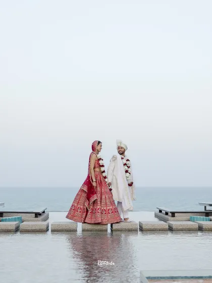 The couple stands by the infinity pool, a serene portrait after their Indian wedding ceremony. The vastness of the sea reflects the journey ahead of them.