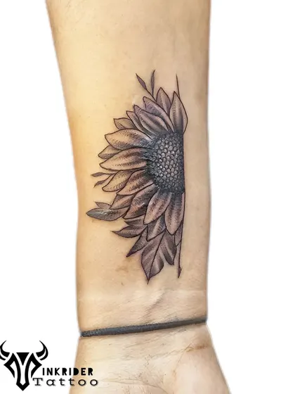 After: This black and grey half-sunflower tattoo was perfectly placed to conceal the wrist scar. The detailed petals and shaded center provide excellent coverage while creating an elegant piece of body art.