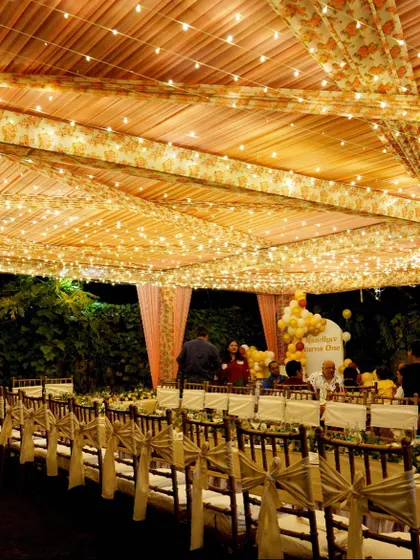 The warm glow of fairy lights adds a festive and enchanting touch to this outdoor tent setup, creating the perfect atmosphere for a memorable celebration.