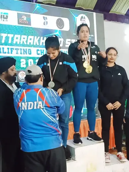 On the podium receiving my second-place medal for full powerlifting. Every competition is a learning experience.