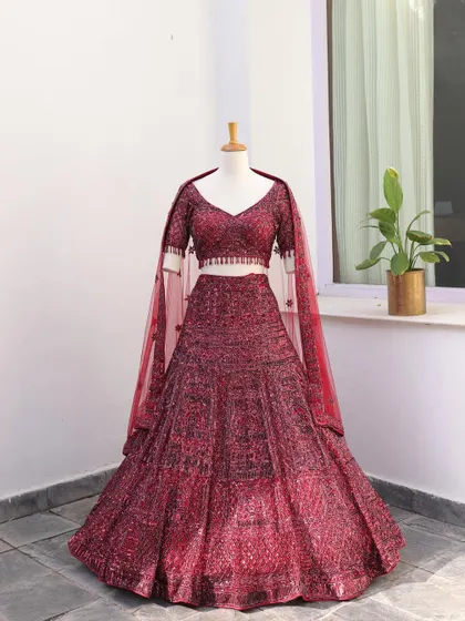The full view of the maroon sequined lehenga. This outfit is all about sparkle and is designed for the bride who wants to shine at her reception or cocktail party.