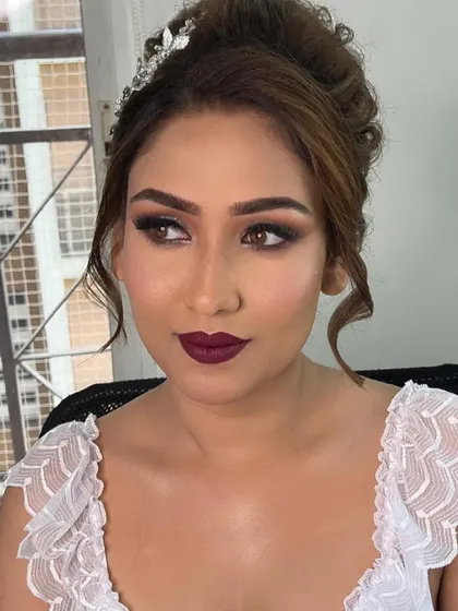 A portrait of the bride, highlighting the bold wine lip color and the expertly blended smokey eye. A truly glamorous and confident bridal look.