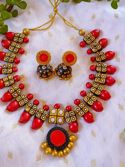 The unique necklace design in a classic red, white, and black combination.