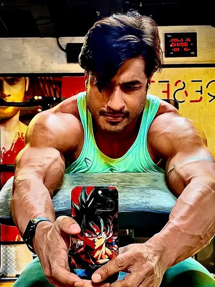 A seated pose showing off my Goku phone case and a physique to match. I am built different because my vision is different.