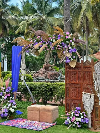 A bohemian-chic photo corner with macrame hangings, pampas grass, and a vibrant blue drape for a pop of color.
