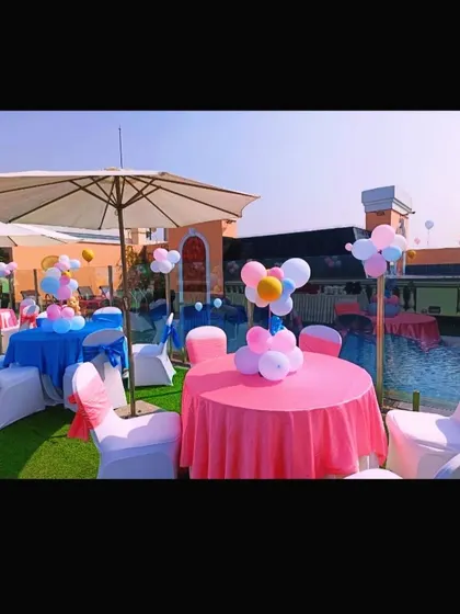 Pink and blue table setups under large umbrellas, perfect for a daytime "he or she" themed baby shower.