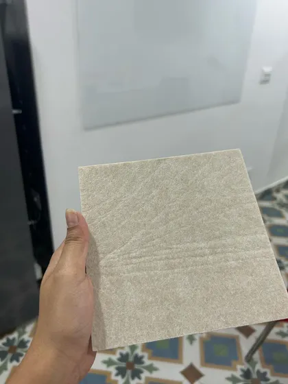 A snapshot from a site visit, holding a tile sample. The process begins with understanding the space, textures, and colors to ensure the mural feels perfectly at home.