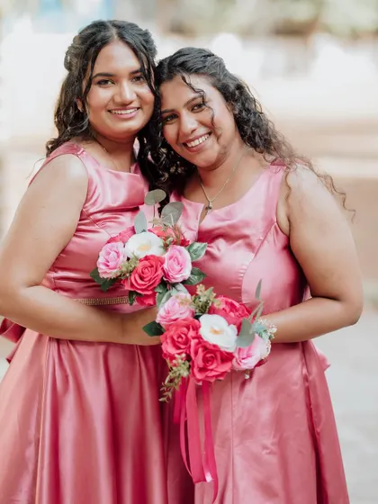 Two lovely bridesmaids in their matching pink dresses, with soft, romantic makeup and hair to match.