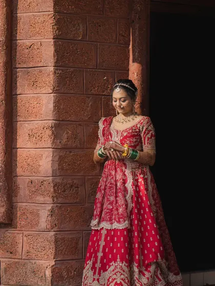A beautiful outdoor shot of my bride Kritika in her red wedding lehenga. The natural light shows off the soft, glowing makeup.
