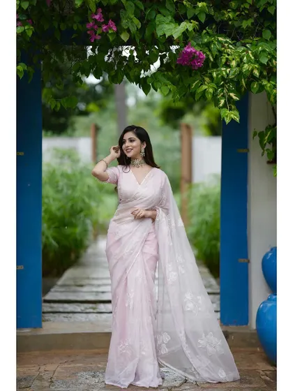 Another shot of the blush pink saree in a beautiful garden setting.