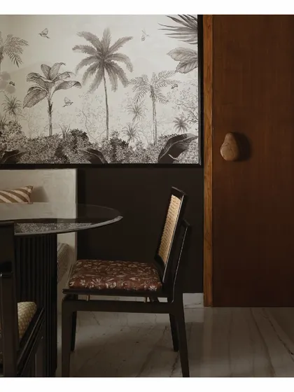 A closer look at the dining nook, where the cement-finished bench seating curves gently. The custom table and cane chairs create an intimate setting, perfect for family meals. The design is all about maximizing space and comfort.