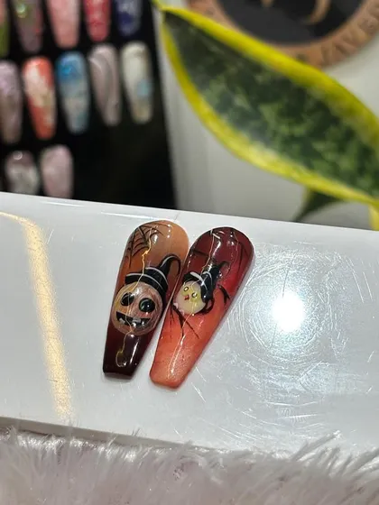 A closer look at two of our Halloween-themed nail tips, featuring a spooky pumpkin and a character from "The Nightmare Before Christmas," both intricately hand-painted with fine details.