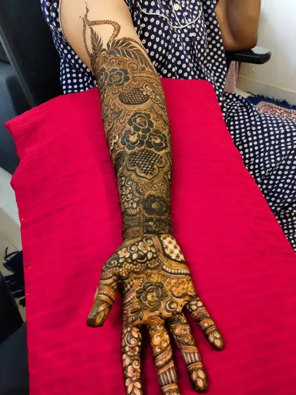 A single-arm view of a bridal design, showing the flow from the hand up to the elbow.