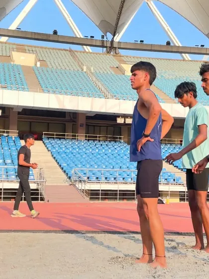 A side view of my athletes in the sand pit, with the impressive JLN stadium in the background. This shows our commitment to using every part of the facility to become better runners.