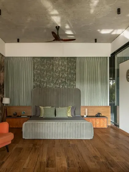 The master bedroom, with its tropical mural and warm wooden flooring, opens directly onto a private terrace, blurring the line between inside and out.