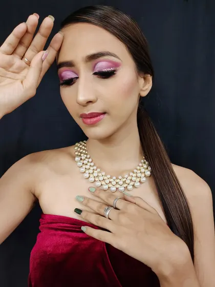This image shows the pink glam look with a sleek ponytail, a great way to keep the focus on the dramatic eye makeup.