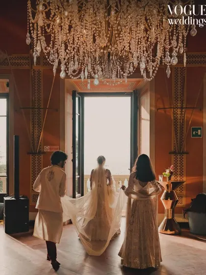 The bride's dramatic exit under a grand chandelier, a cinematic shot that was part of the Vogue Weddings story.