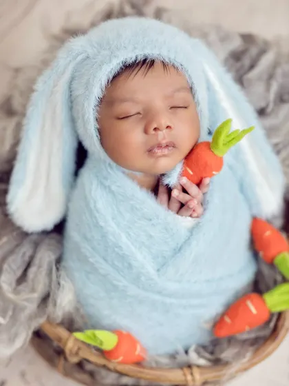 A close-up on the little bunny's face, holding a tiny carrot. These themed shoots are all about capturing personality and charm.