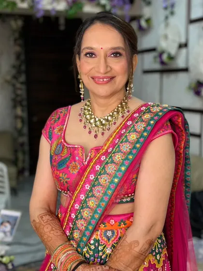 A stunning makeup look for the bride's mom. The vibrant pink and green lehenga is paired with a soft, glowing makeup look.