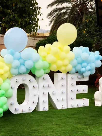 A light-up "ONE" sign decorated with pastel balloons and a cute rabbit prop, creating a perfect photo spot to celebrate the big milestone.