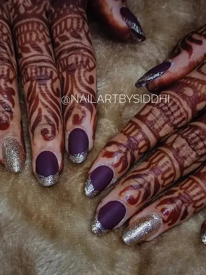 A modern bridal look for a bride who wants a pop of color. This set features a matte purple polish with sparkling silver French tips, shown here with bridal henna.