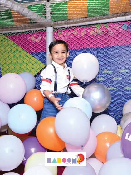 A birthday boy surrounded by balloons in our play area. It's a simple, classic way to have a whole lot of fun.
