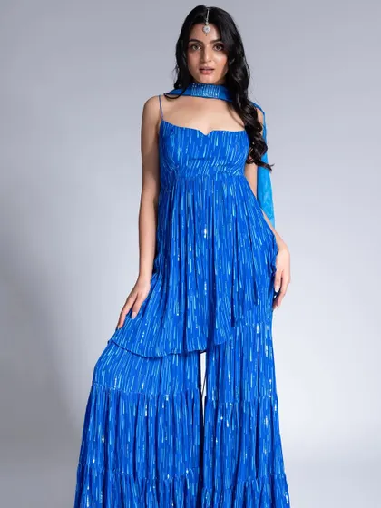 A vibrant look for the Label Shivani Nirupam campaign. The makeup is fresh and dewy with a simple maang tikka, letting the electric blue of the sharara set be the hero.
