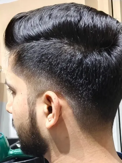A perfect haircut and beard trim. This photo shows a clean fade and well-groomed beard.