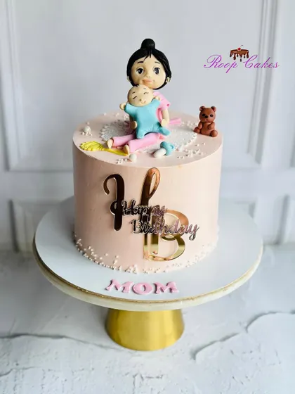 A beautiful handcrafted edible figurine of a mom and her baby, made for a special first birthday celebration.