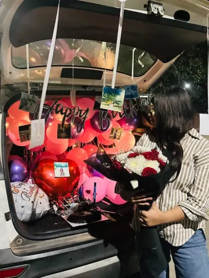 A beautiful shot of the birthday girl enjoying her surprise, with the decorated car trunk glowing in the background.