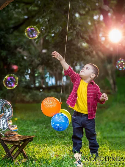 A little boy reaches for bubbles in a sun-drenched park. This action shot perfectly captures the wonder and joy of a child playing outdoors.